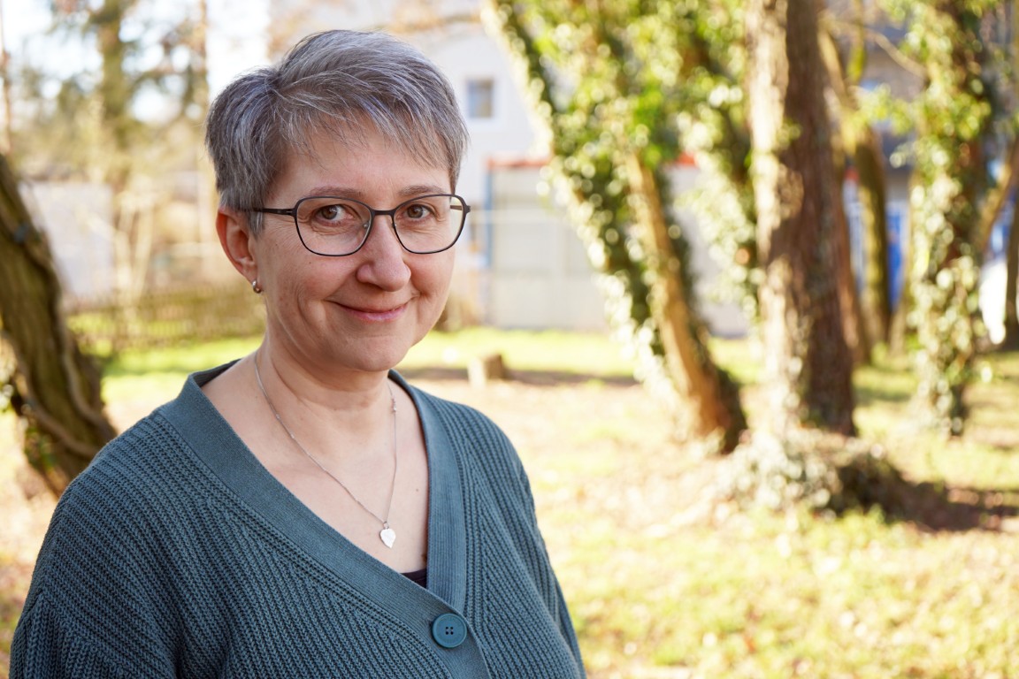 Eine Dame schaut freundlich in die Kamera.