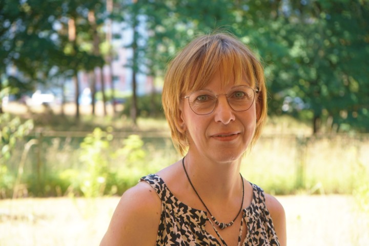 Eine Dame mit dunkelblonden kurzen Haaren und einer Brille schaut freundlich in die Kamera.